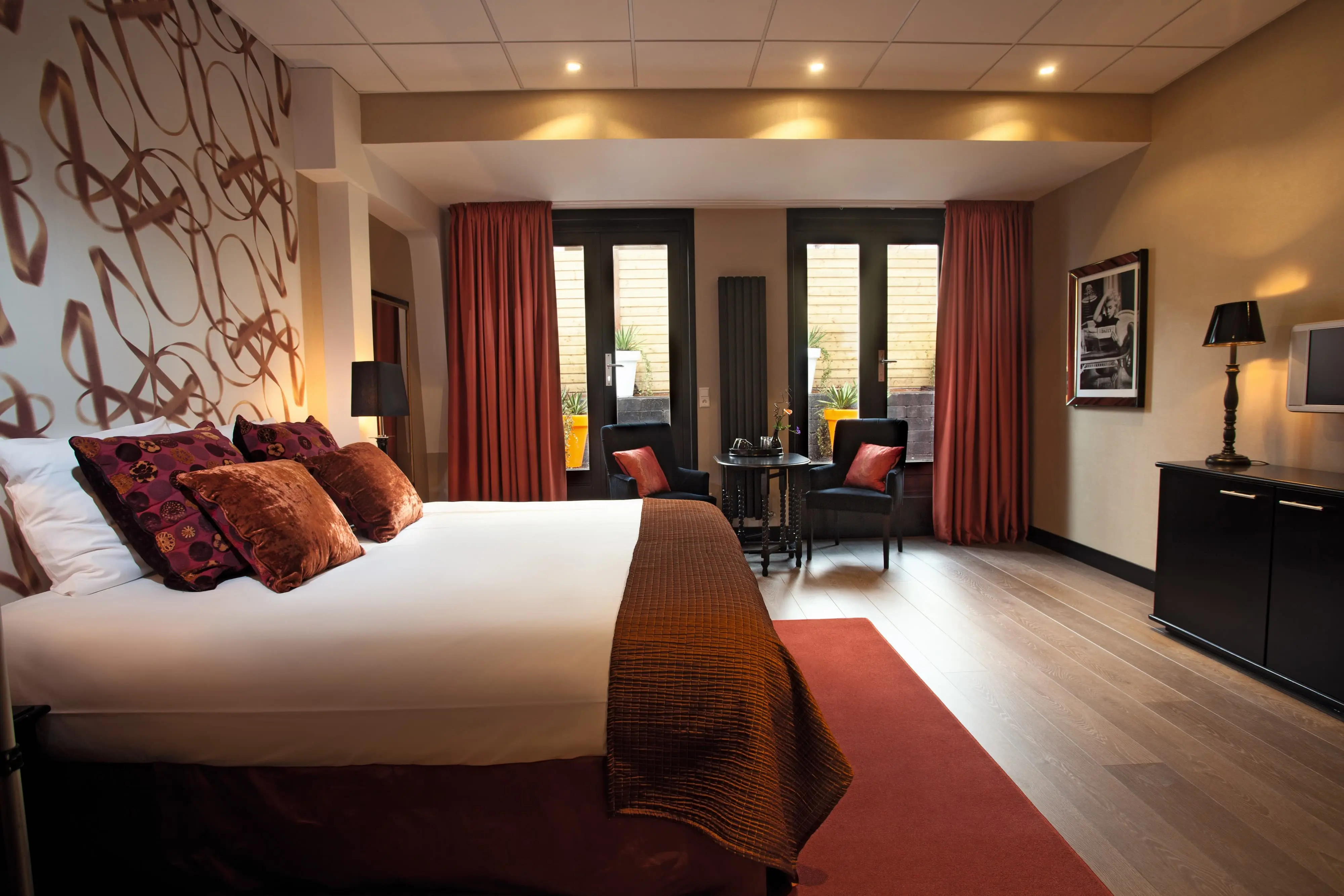 Warmly lit hotel room interior with plush textures and a canal view